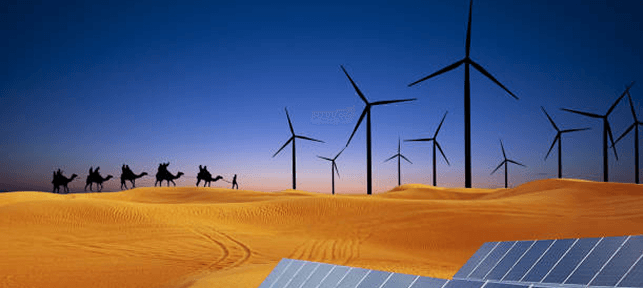 Wind turbines in the desert with camels at sunset