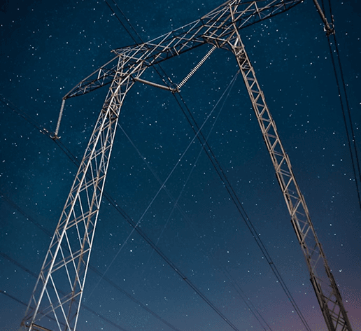 Power transmission towers against a starry night sky